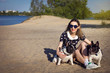 Beautiful girl on the beach with two french bulldogs
