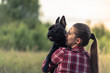 Attractive woman kissing French Bulldog puppy