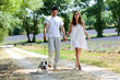 young happy man woman couple walking with dog summer vacation